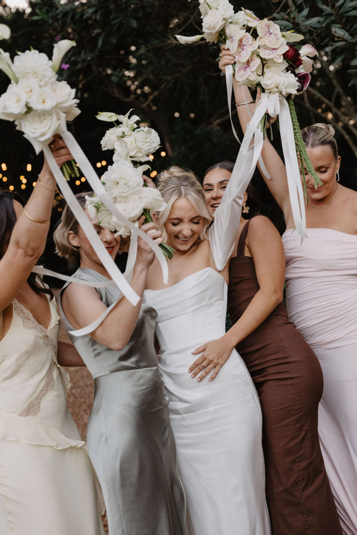 Bridesmaids in neutral dresses standing together at Anna and Jacky’s Gabbinbar wedding, Queensland