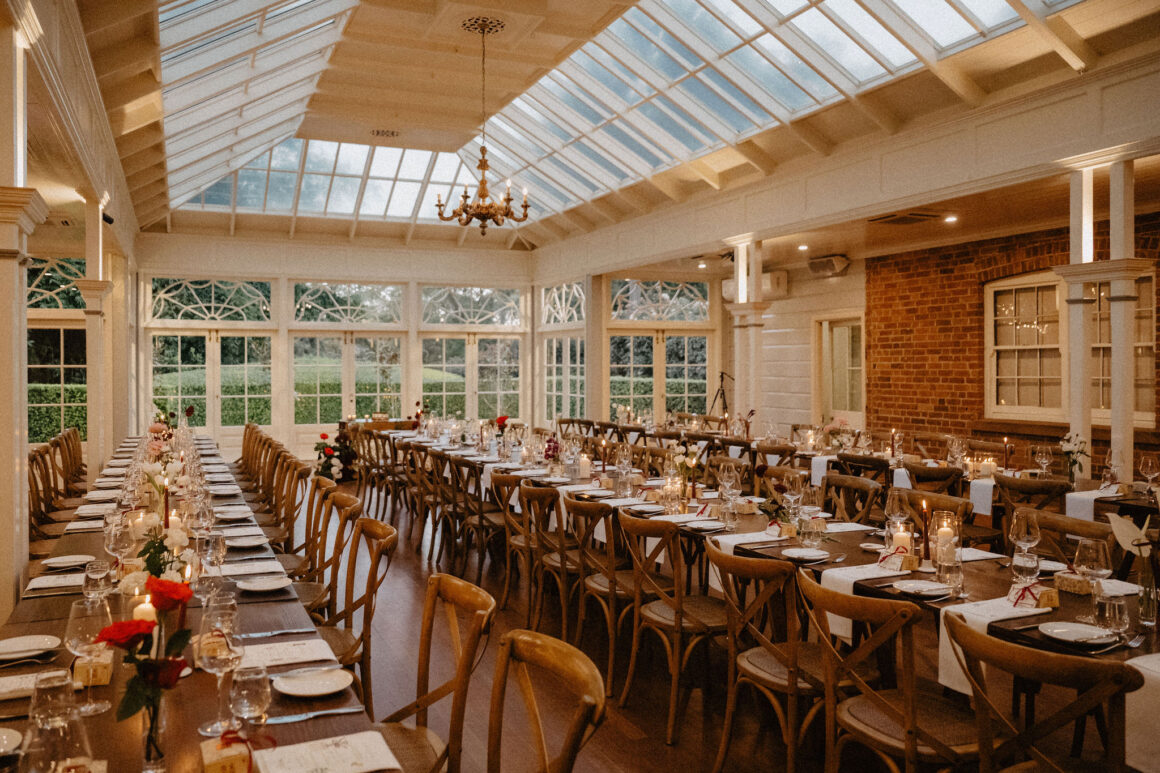 Reception styling at Anna and Jacky’s Gabbinbar wedding, featuring red and white floral arrangements, and handcrafted menu cards on elegantly set tables.