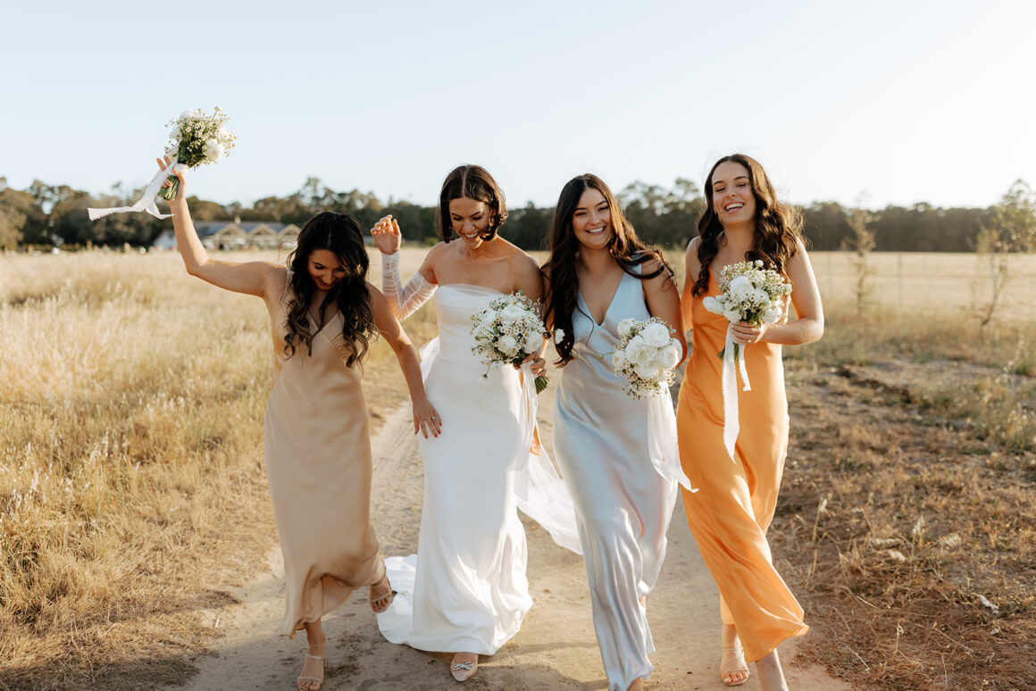 Bridal party in mismatched earthy-toned bridesmaid dresses by Bec + Bridge