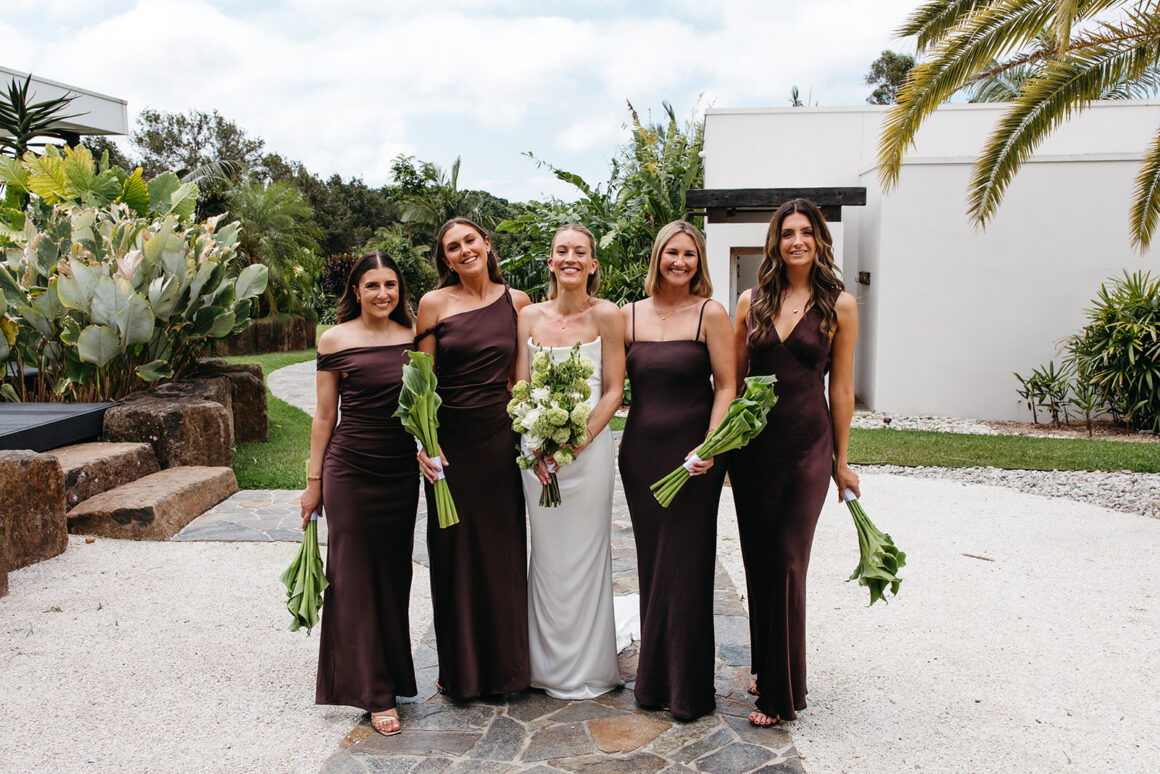 Bridesmaids wearing brown Bec and Bridge dresses holding unique green bouquets