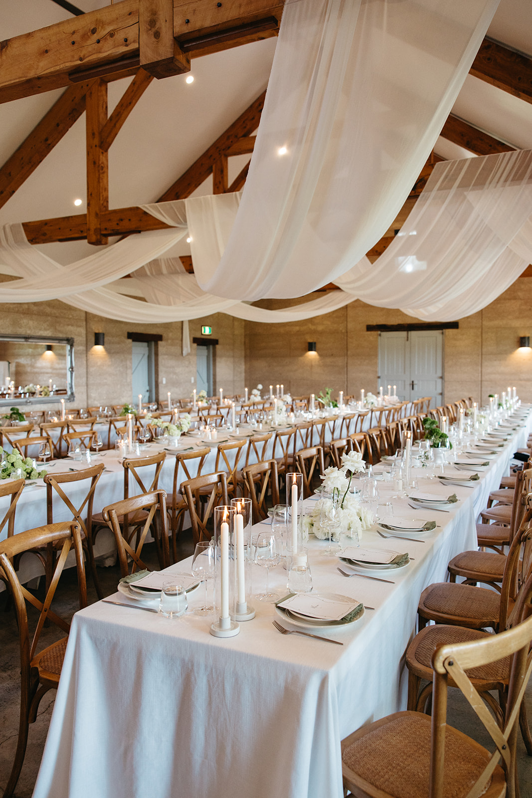 Long table reception styled like a dinner party with candles and shared plates in Byron Bay