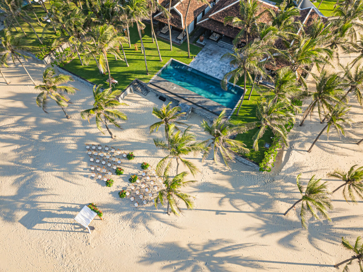 Beachside wedding ceremony at Four Seasons The Nam Hai Vietnam with ocean backdrop and tropical setting
