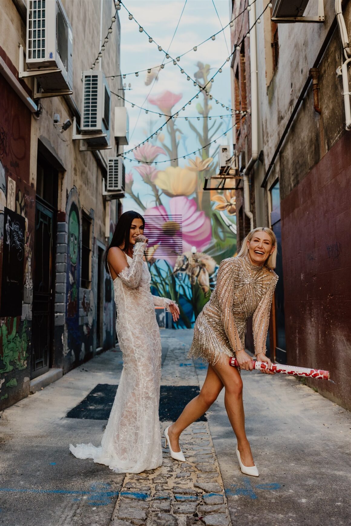Brides wearing sparkling Albina Dyla mini dress and Grace Loves Lace gown at intimate Perth wedding