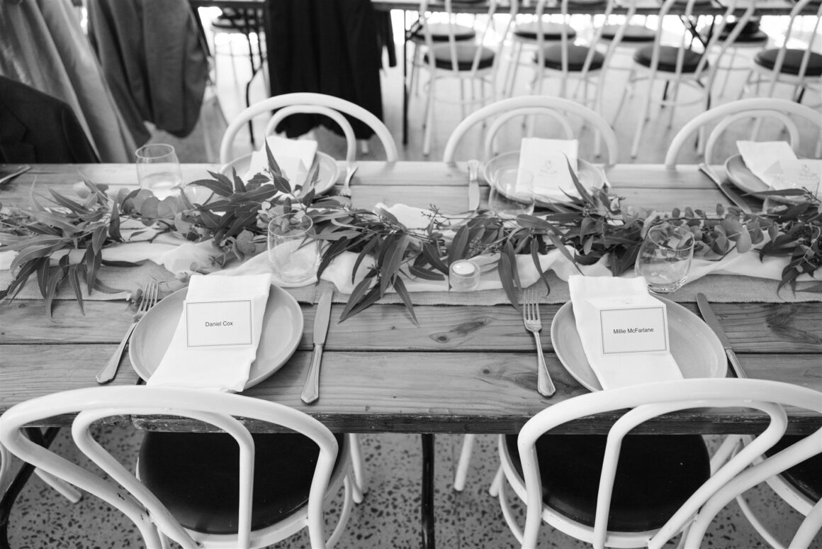 Rustic wedding reception tables decorated with eucalyptus foliage