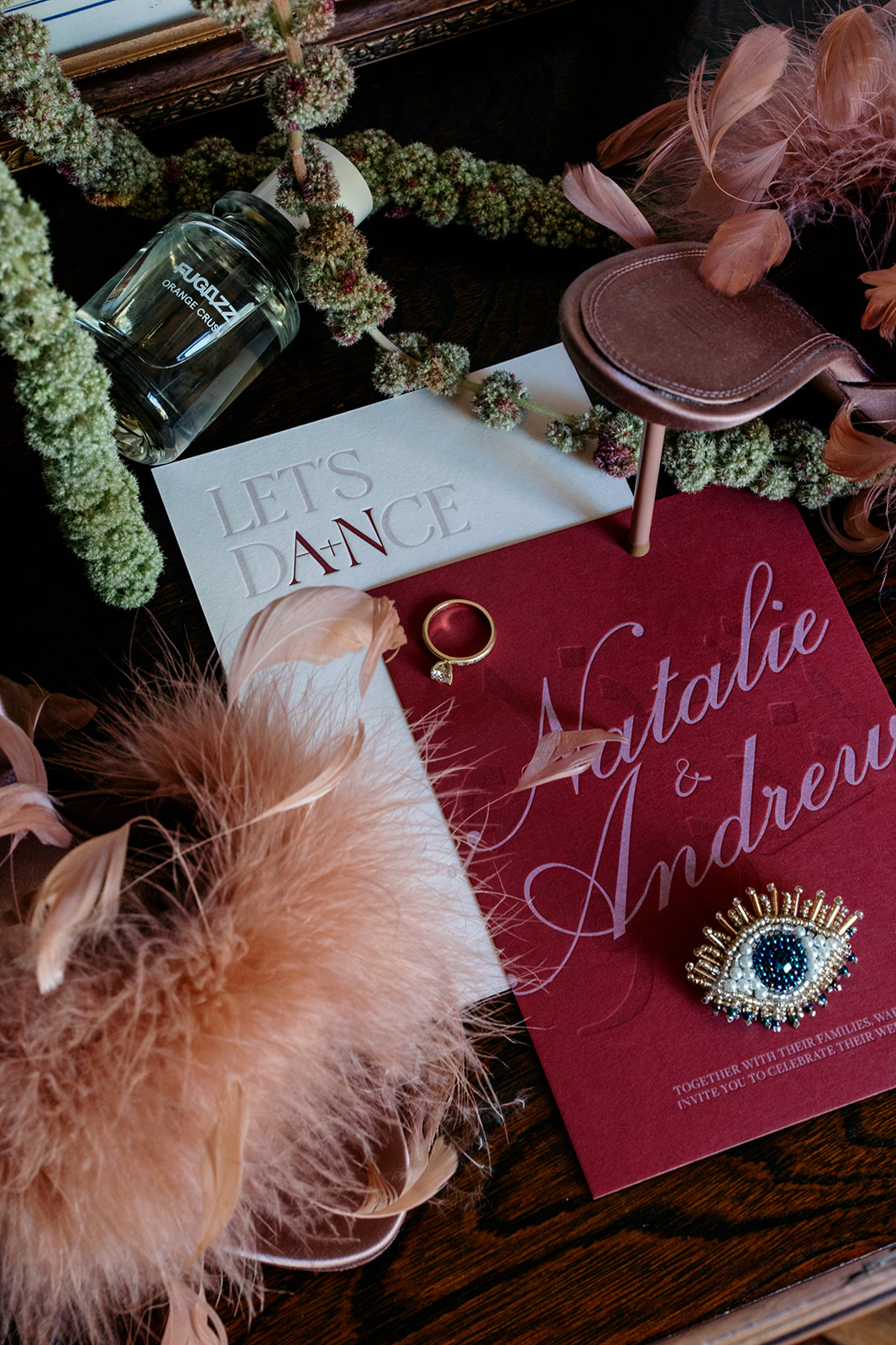 edding flat lay with invitation suite, sapphire evil eye ring, pink feathers and moss garland – Natalie and Andrew's Melbourne winery wedding photographed by Kinship by Kristy