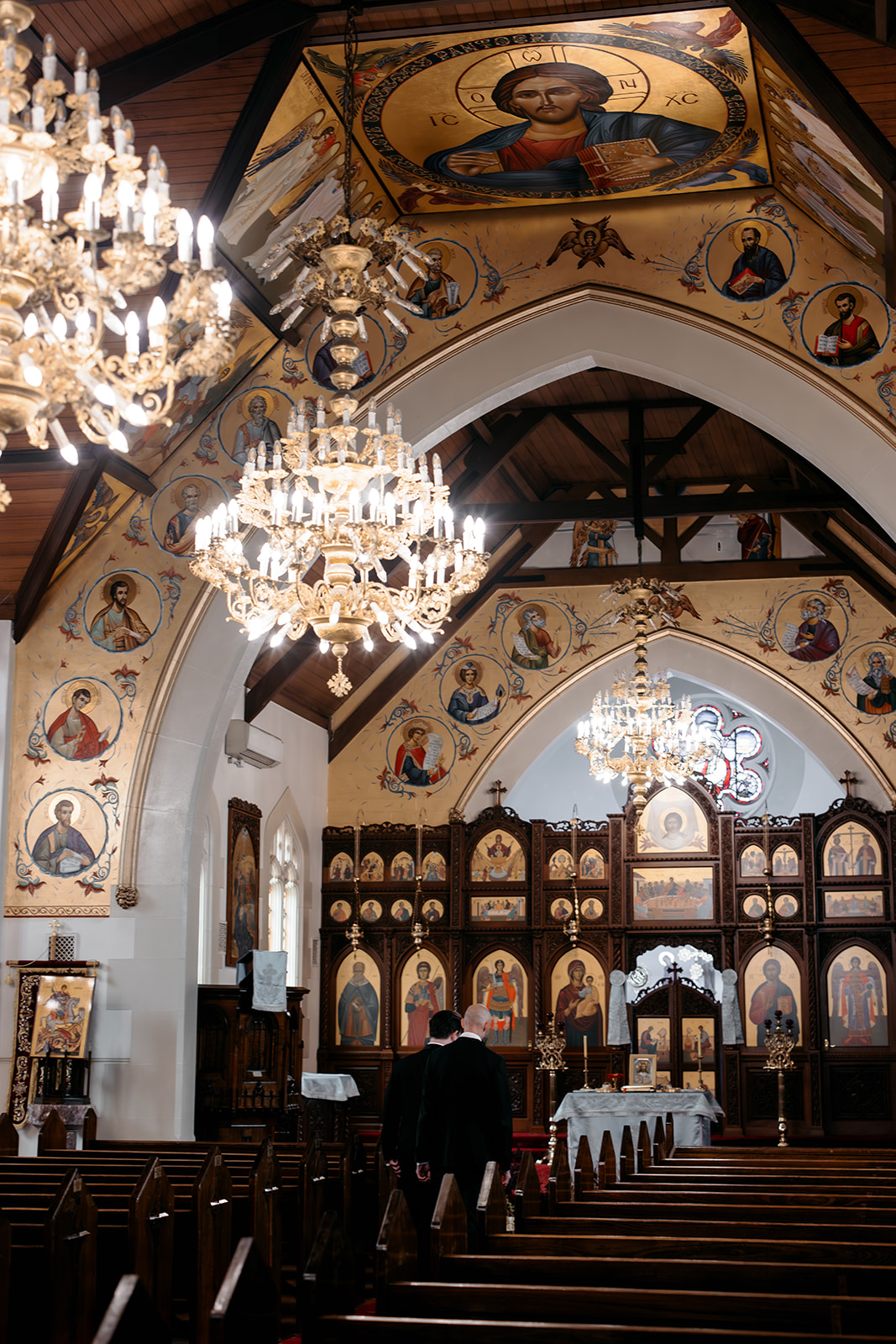 Interior of a Melbourne Orthodox church decorated with Byzantine icons, chandelier lighting and ornate woodwork ahead of Natalie and Andrew's wedding ceremony, photographed by Kinship by Kristy